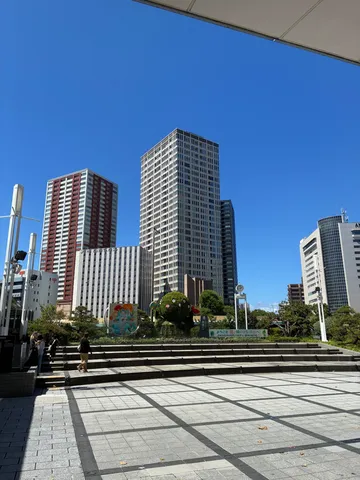 都会のオアシス！緑のキャラクターと高層ビル群