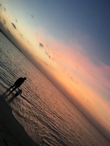夕暮れの海辺、二人のシルエット