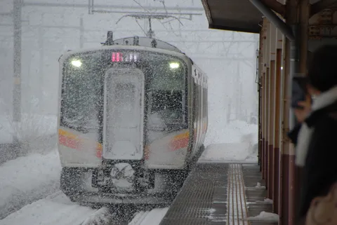 吹雪の中、静かに佇む列車
