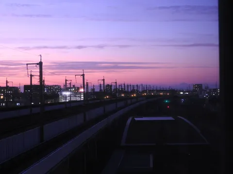 夜明け前の線路と街の灯り