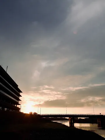 夕暮れのビルと橋、静かな水面