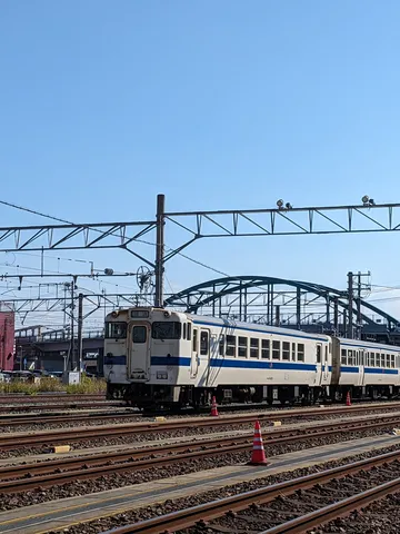 青空の下、車両基地を走る電車