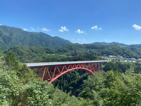 新緑に映える赤いアーチ橋