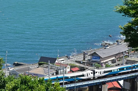 海沿いを走る青い列車