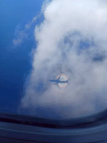 飛行機雲に映る虹の輪