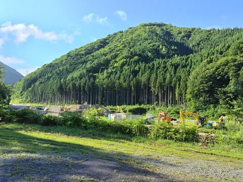 山麓の工事現場と緑のコントラスト