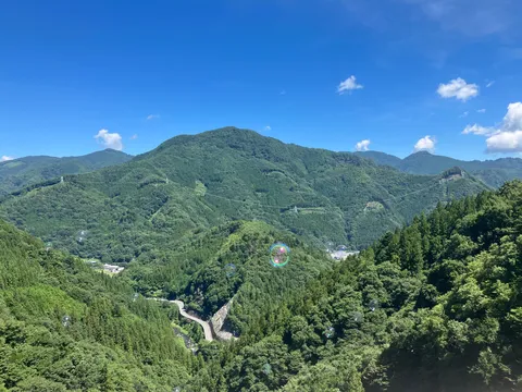 山間の道と空に浮かぶシャボン玉