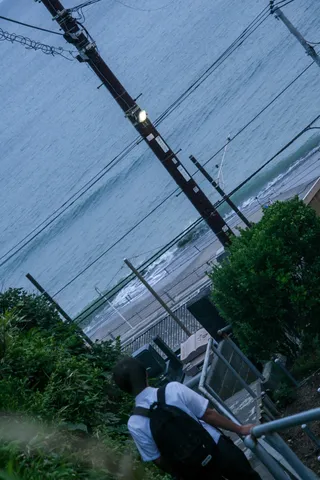 雨上がりの海辺、背中で語る人