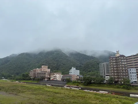 霧に包まれた山と川沿いの街並み