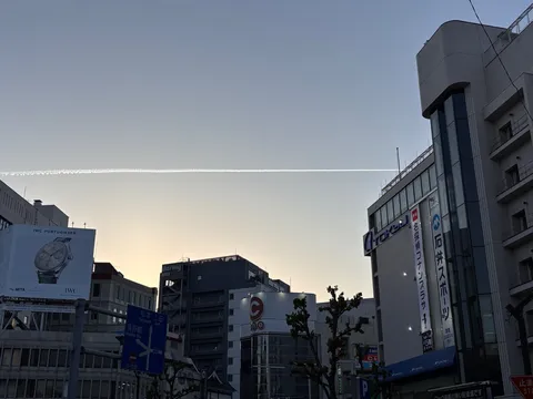 空に伸びる人工の軌跡、都市の日常
