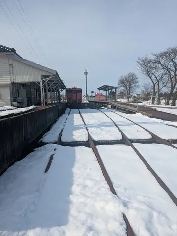 雪の駅舎と赤い列車