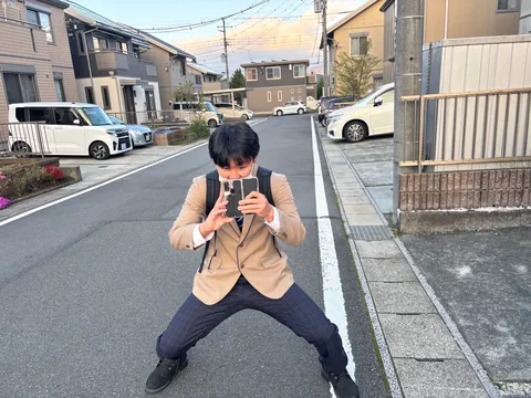 スマホを構える、午後の路地裏