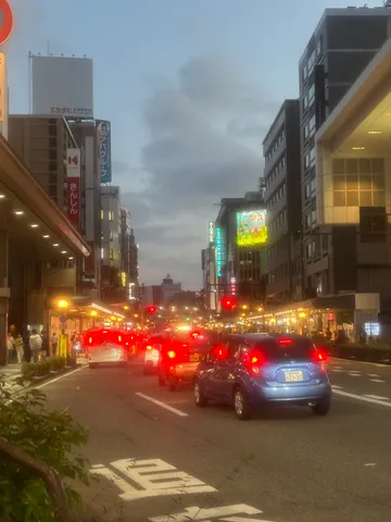 夕暮れの街、車のヘッドライトとテールランプが灯る