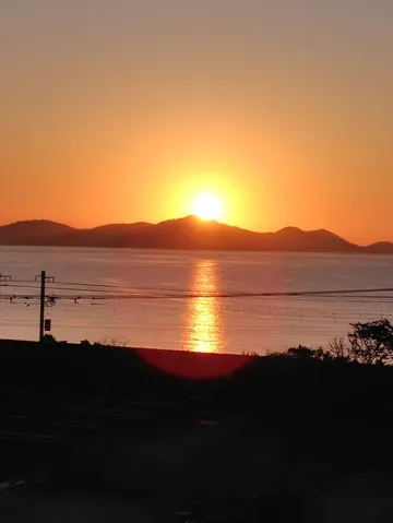 夕焼けに染まる島影、電線がアクセント