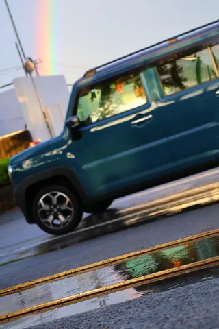 雨上がりの虹と青い車