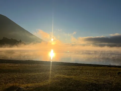 朝靄に染まる湖面、幻想的な水鏡