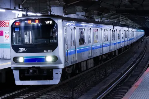 夜の駅に滑り込む銀色の列車