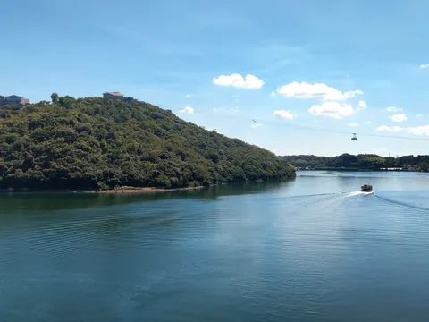 水面を滑る船と、緑豊かな丘の風景