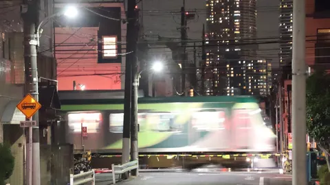 都会の夜、電車が駆け抜ける光景