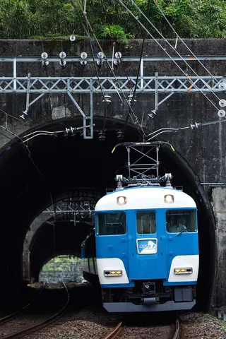 トンネルから現れる青い電車
