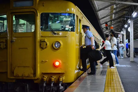 夜の駅、黄色い車両と乗り降りのドラマ