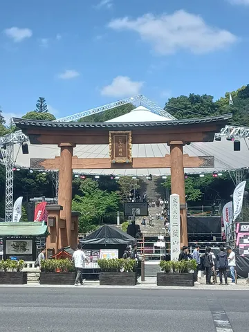 晴天の下、厳かな鳥居と賑わい