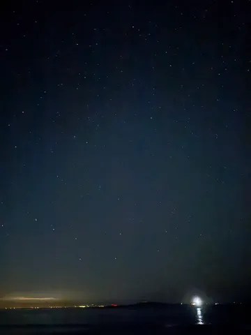 星降る夜、海辺の灯り