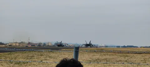 離陸する戦闘機、煙をまとい