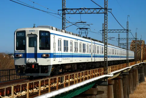 青空と白い電車、架線下の旅