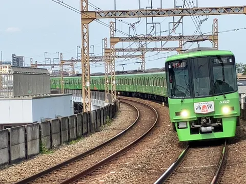 カーブを抜ける鮮やかな緑の車両