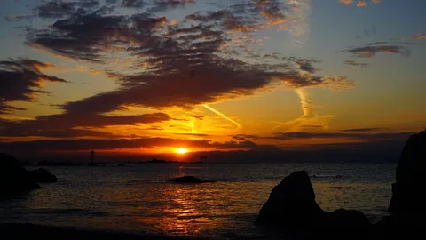 夕焼け空と灯台のシルエット