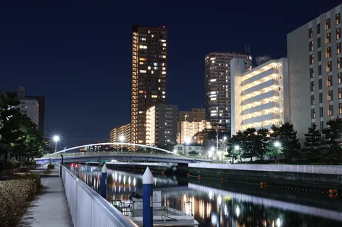 夜の水路に映る光の街