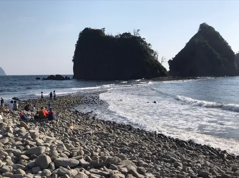 海辺に佇む人々、波音に癒やされる風景