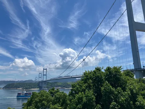 青空と巨大な橋、海を行く貨物船