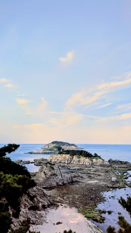 緑と岩肌のコントラスト、遠くの島影
