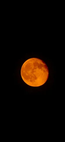 深まる夜のオレンジ色の月