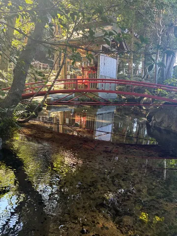 水辺の神社と赤い橋の影