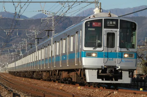 青い帯が輝く、西へ向かう特急列車