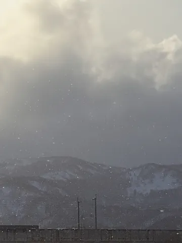 雪と風の山影に光る