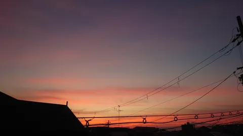 紫とオレンジの空、電線が描く線