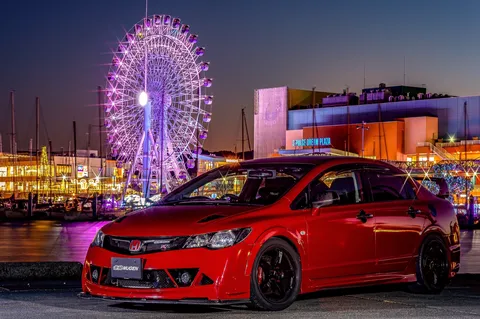 煌めく観覧車と赤い車