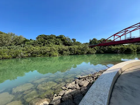 赤橋と緑の川辺のコントラスト
