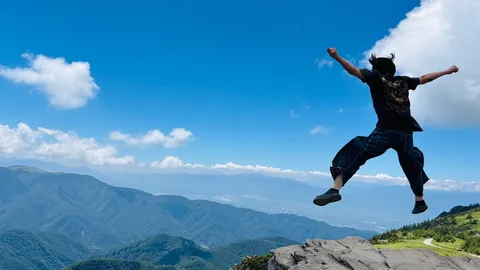山頂で弾ける自由な跳躍