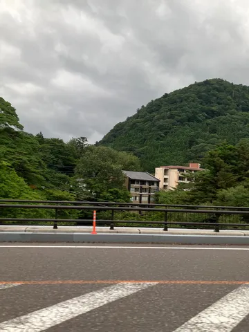 山の緑と空、都会のコントラスト