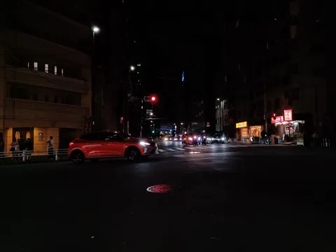 夜の交差点に走る赤い影