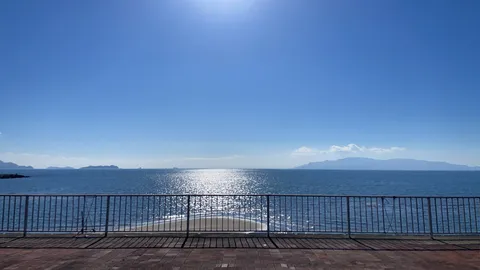 太陽がきらめく海辺の散歩道