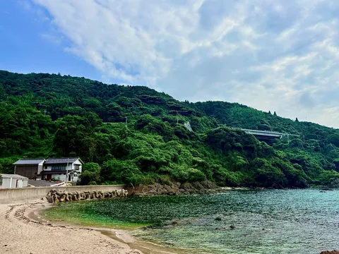 海辺の静かな集落と緑の山