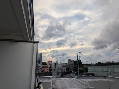 夕暮れの街角と雲の間