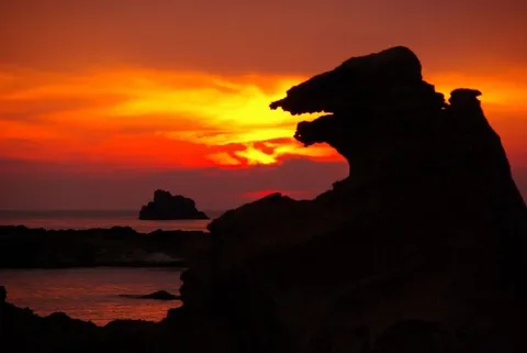 沈む夕陽と岩の影