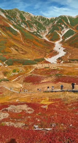 秋の山里を歩く旅人たち